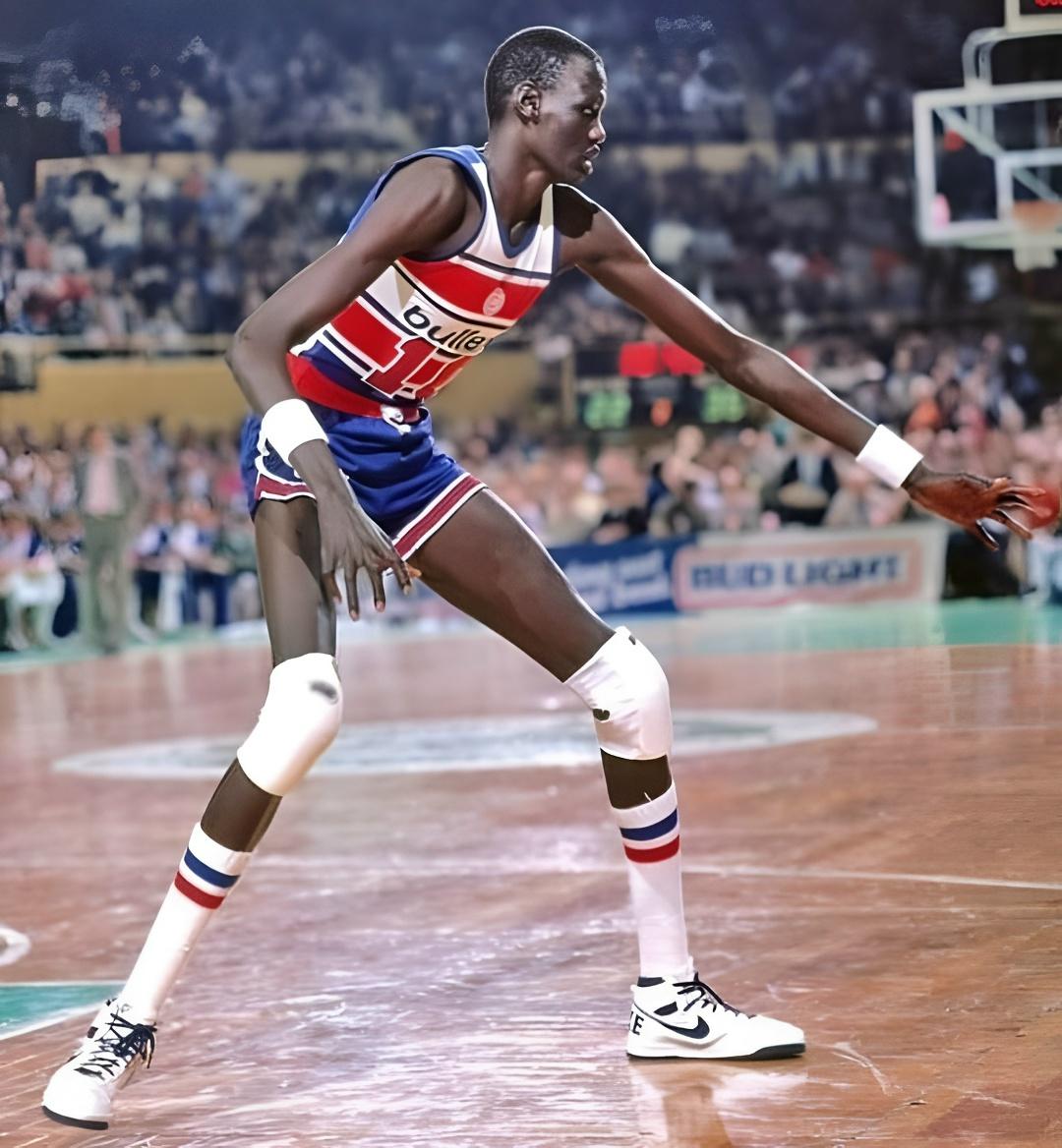 С ростом 2 метра 31 сантиметр Мануте Бол казался пришельцем даже в лиге гигантов. На фоне атлетичных игроков НБА его фигура выглядела сюрреалистично: невероятно узкие плечи, бесконечно длинные руки и силуэт, устремленный в небо.